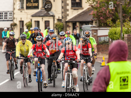 I ciclisti attraversa passando il famoso stagno in Lindfield durante il 2013 Londra a Brighton in bicicletta. Foto Stock