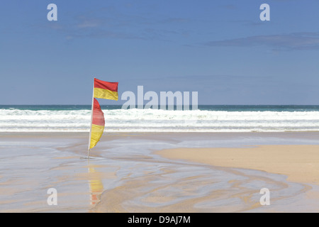 Rosso e giallo di sicuro la zona di balneazione bandiera, Fistral Beach, Newquay Cornwall Inghilterra area lifeguarded britannico scena di surf Foto Stock