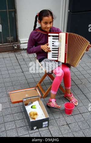 Bambina a suonare la fisarmonica mentre sorridente su strada Foto Stock