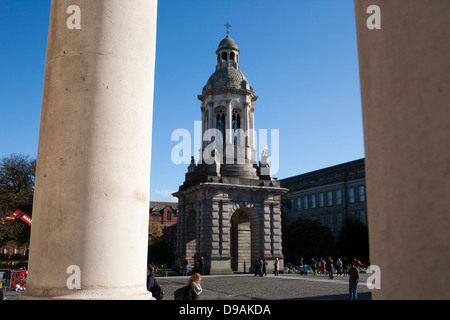 Una donna cammina davanti il campanile in piazza del Parlamento nella motivazione del Trinity College di Dublino in Repubblica di Irlanda Foto Stock