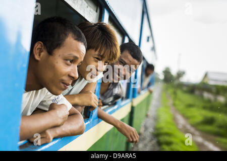 Yangon, Unione di Myanmar. Il 15 giugno, 2013. Passeggeri sporgersi dai finestrini di Yangon treno circolare. Essi Yangon ferroviaria circolare è il locale dei pendolari rete ferroviaria che serve il Yangon area metropolitana. Azionato da Myanmar Ferrovie, 45,9-chilometro (28.5Â mi) 39-stazione di sistema ad anello collega città satelliti e zone di periferia della città. La ferrovia ha circa 200 autobus, esegue 20 volte e vende 100.000 a 150.000 biglietti giornalieri. Il loop che richiede circa tre ore per completare, è un popolare per i turisti a vedere una sezione della vita di Yangon. I treni da 3:45 a 10:15 Foto Stock