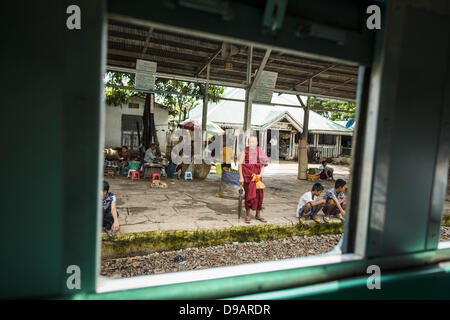 Yangon, Unione di Myanmar. Il 15 giugno, 2013. Un monaco buddista come visto attraverso la finestra a Yangon treno circolare. L Arcidiocesi di Yangon ferroviaria circolare è il locale dei pendolari rete ferroviaria che serve il Yangon area metropolitana. Azionato da Myanmar Ferrovie, 45,9-chilometro (28.5Â mi) 39-stazione di sistema ad anello collega città satelliti e zone di periferia della città. La ferrovia ha circa 200 autobus, esegue 20 volte e vende 100.000 a 150.000 biglietti giornalieri. Il loop che richiede circa tre ore per completare, è un popolare per i turisti a vedere una sezione della vita di Yangon. I treni da 3:45 am t Foto Stock