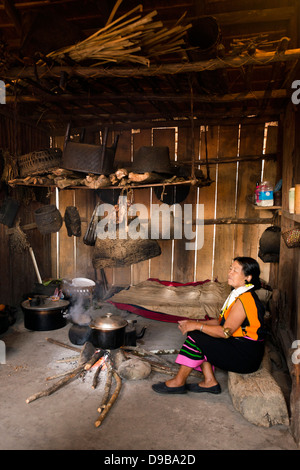 Naga tribeswoman cottura in una capanna, Kisama, Kohima, Nagaland, India Foto Stock