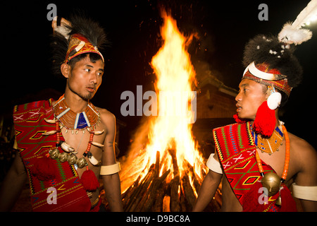 Naga tribesmen davanti al fuoco durante l'annuale Festival Hornbill a Kisama, Kohima, Nagaland, India Foto Stock