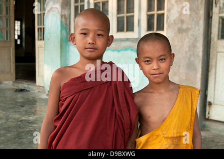 Due boy i monaci buddisti sorridente in parte anteriore del monastero porta il Myanmar (Birmania) Foto Stock