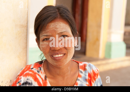 Testa e spalle il ritratto di una bella donna birmana con la faccia coperta in legno di sandalo thanakha incolla come specchio del Myanmar (Birmania) Foto Stock