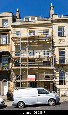 Ponteggio e costruttori van al di fuori di una vecchia casa in fase di ripristino, England, Regno Unito Foto Stock