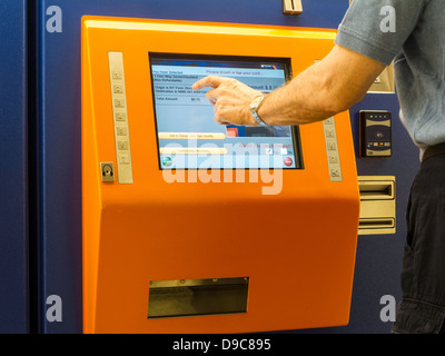 L'uomo Acquisto di New Jersey Transit i biglietti del treno a Self Service Distributore, Penn Station, NYC Foto Stock