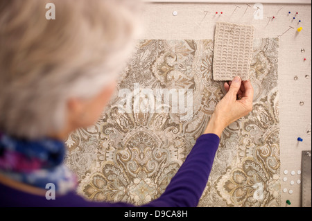 Senior donna scegliendo i campioni di materie tessili Foto Stock