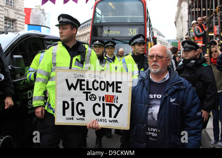 Protester con targhetta sorge nella parte anteriore della linea di polizia durante il G8 proteste a Londra Foto Stock