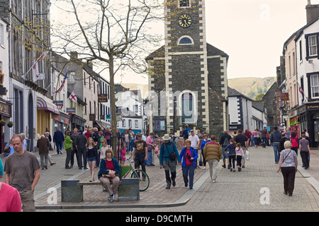 Gli amanti dello shopping a Keswick piazza del mercato con il controverso nella hall la distanza. Cumbria Lake District Foto Stock