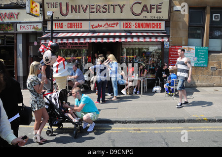 Una strada trafficata scena presso l'Università Café durante il west end festival su Byres Road, Glasgow, Scotland, Regno Unito Foto Stock