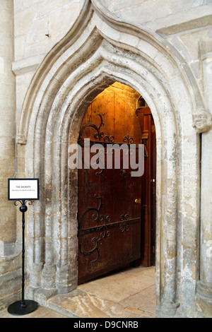 La porta che conduce alla sagrestia, una camera in cui un sacerdote si prepara per un servizio, Peterborough Cathedral, Inghilterra Foto Stock