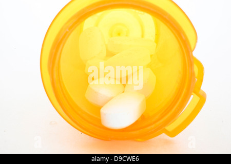Pillole di prescrizione in un contenitore arancione isolata contro uno sfondo bianco Foto Stock