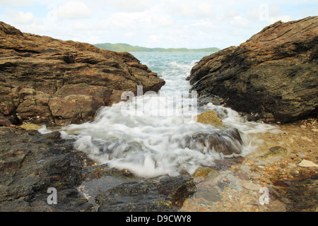 Le onde del mare di colpire round rocce e schizzi Foto Stock