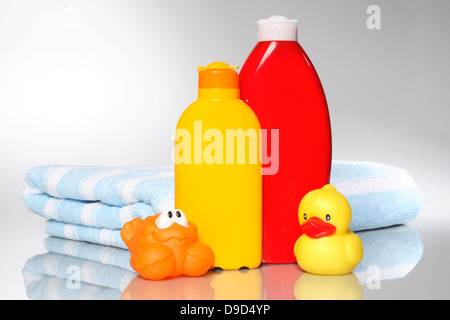 Latte solare, lozione, asciugamano e animali elastico Foto Stock