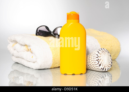 Teli da Bagno con latte solare e occhiali da sole Foto Stock