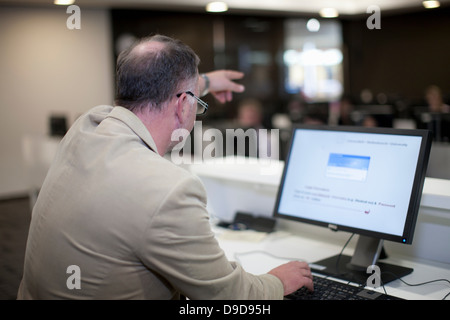 Docente utilizzando computer puntando al retro della camera Foto Stock