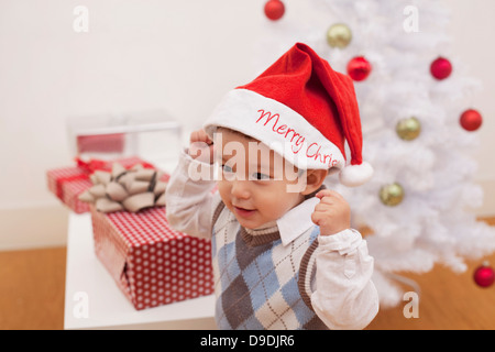 Ragazzo che indossa Santa hat nella parte anteriore delle decorazioni di Natale Foto Stock