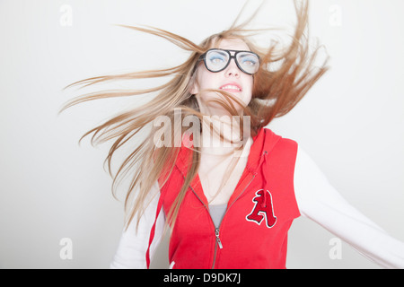 Ragazza che indossa gli occhiali finti capelli oscillanti Foto Stock