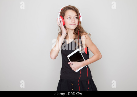 Ragazza con tavoletta digitale, indossando le cuffie Foto Stock