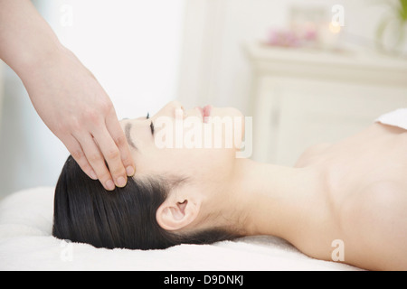 Donna avente testa massaggiato Foto Stock
