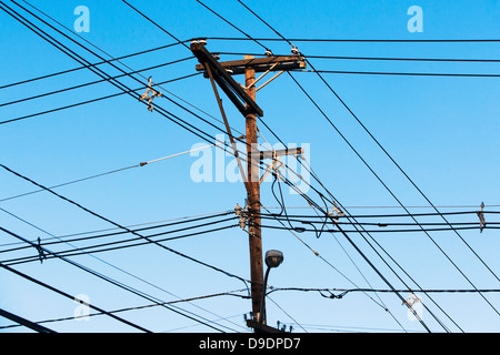 Cavi fissati al palo del telegrafo contro il cielo blu Foto Stock