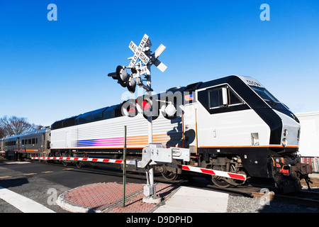 Treni passeggeri passando passaggio a livello Foto Stock