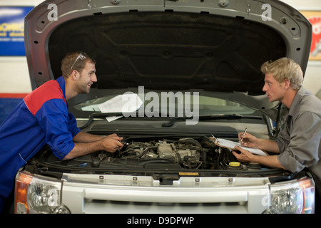 Meccanica auto a discutere e analizzare riparazione auto Foto Stock