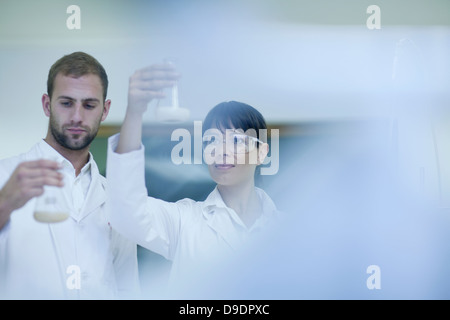 Tecnici di laboratorio controllo contenuto nel becher di laboratorio Foto Stock