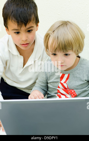 Due bambini staring al laptop Foto Stock