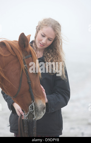 La donna a cavallo sulla spiaggia Foto Stock