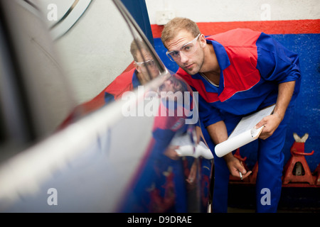 Autofficine a lavorare nella baia di servizio Foto Stock