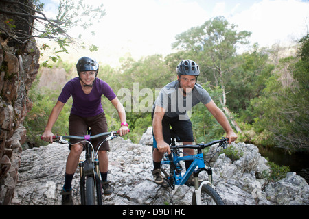 Ritratto di giovane coppia con mountain bike su roccia Foto Stock