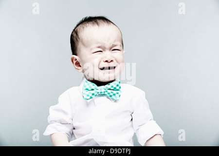 Ritratto di baby boy indossando camicia e il filtro bow tie, pianto Foto Stock