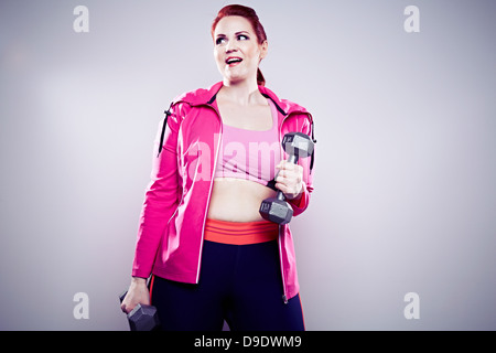 Giovane donna utilizzando i pesi a mano Foto Stock