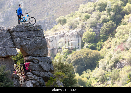 Mountain bike matura sulla formazione di roccia guardando avanti Foto Stock