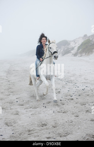 La donna a cavallo sulla spiaggia Foto Stock