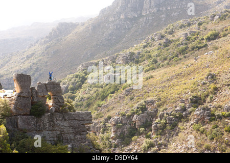 Vista in lontananza giovane con mountain bike su roccia Foto Stock