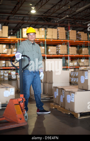 Ritratto di metà uomo adulto mediante martinetto pallet Foto Stock