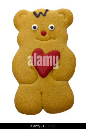 Orsacchiotto di peluche gingerbread biscotto con cuore rosso nelle sue zampe isolato su bianco. Foto Stock