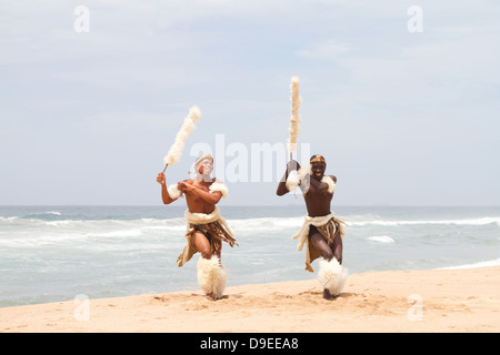 African Zulu uomo balli sulla spiaggia Foto Stock