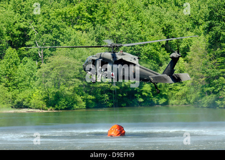 Un UH-60 Blackhawk elicottero riempie sospeso un secchio di acqua nel Lago Marquette, Pennsylvania. Foto Stock