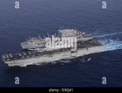 USS Kearsarge tira a fianco USNS Lewis e Clark per un riempimento al mare. Foto Stock