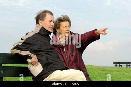 Senior Citizen's coppia siede su un parco-Bench (Modello di rilascio) Foto Stock