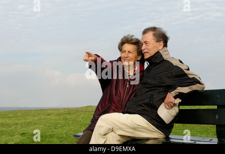 Senior Citizen's coppia siede su un parco-Bench (Modello di rilascio) Foto Stock