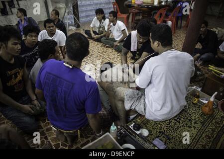 Marzo 23, 2013 - Nakhon Chai Si - devoti della Thailandia del Wat Bang Pra hanno loro tatuaggio è eccitato mentre frequentano un festival chiamato ''Wai Kru'' vicino a Nakhon Chasi Sabato, 26 marzo 2013. I devoti hanno loro tatuaggio è eccitato da Tattoo mastri e monaci buddisti. La maggior parte dei devoti credono che i tatuaggi sono magia e proteggerli contro tali cose come i proiettili e coltelli. (Credito Immagine: © David Longstreath/ZUMAPRESS.com) Foto Stock