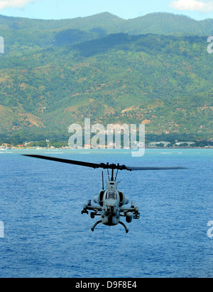 Un AH-1W Super Cobra vola al largo della costa di Dili, Timor Est. Foto Stock