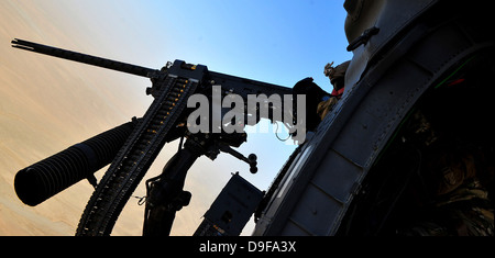 Soldier mans il 0,50 Caliber machine gun su un HH-60G Pave Hawk. Foto Stock