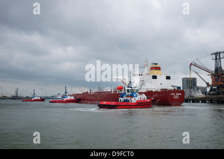 Rimorchiatori manovra di una superpetroliera nave nel porto di Rotterdam, Paesi Bassi Foto Stock